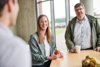 Mitarbeitende sitzen gemeinsam in der campus cantine und unterhalten sich.