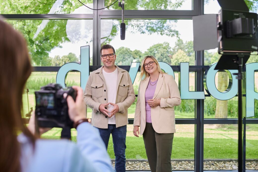 Zwei Kollegen:innen werden im Fotostudio fotografiert.