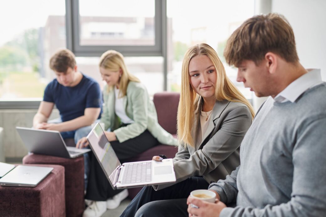 Kollegin und ein Praktikant sitzen zusammen.