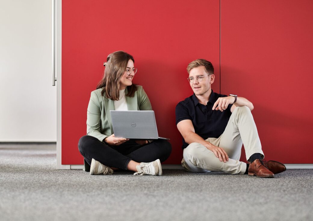 Werkstudierende spricht mit ihrem Kollegen über ihr gemeinsames Projekt.