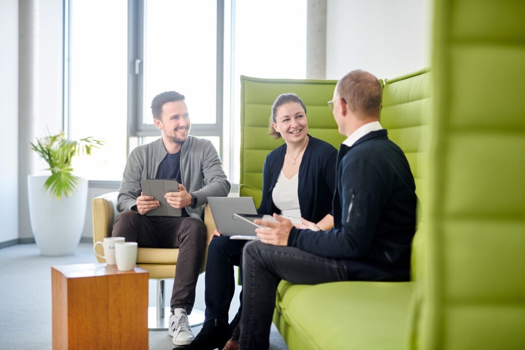 Marketeers sitzen mit einem zufriedenen Kunden zusammen.