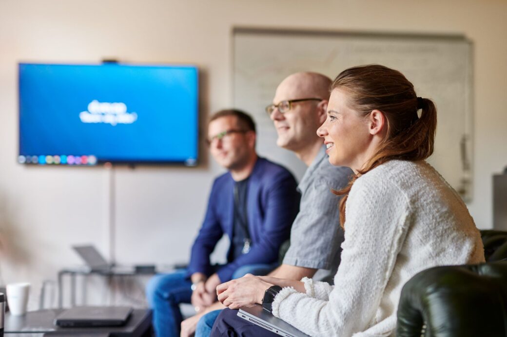 Mitarbeitende aus dem Consulting sitzen in einer Besprechung.